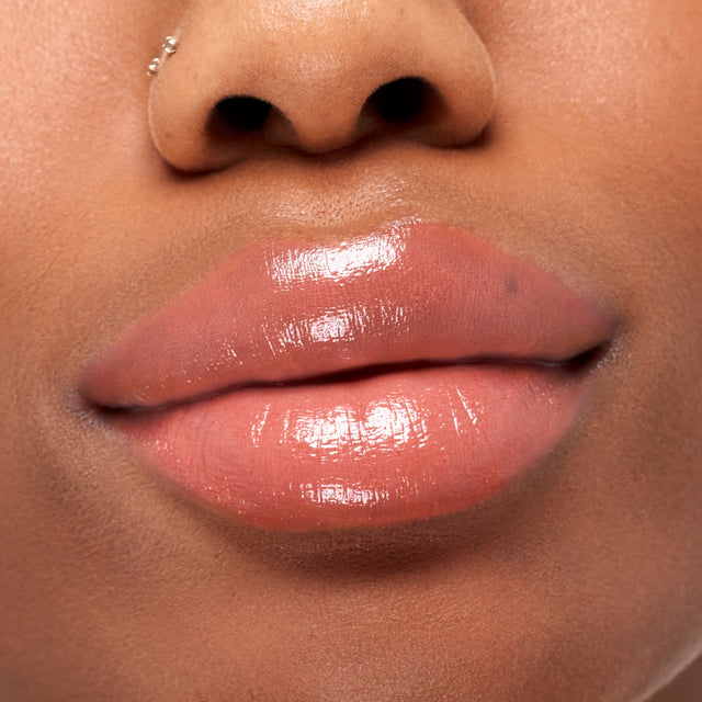 Deep skin tone model wearing Wet Stick in Papaya Treat