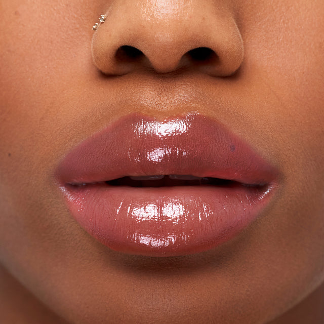 Deep skin tone model wearing Wet Stick in 100 Degrees