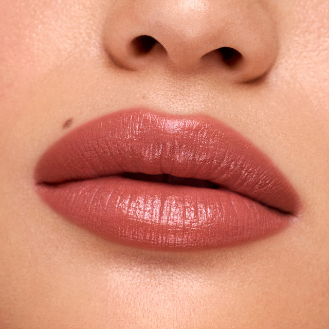 Medium skin tone model wearing Weightless Lip Color in Turned On