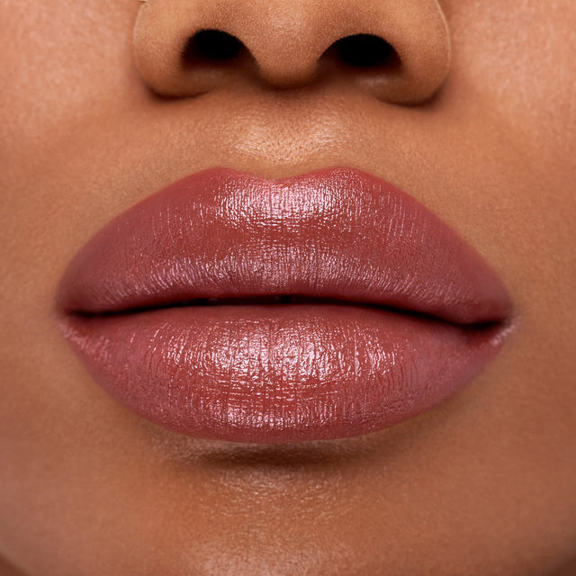 Deep skin tone model wearing Weightless Lip Color in Turned On