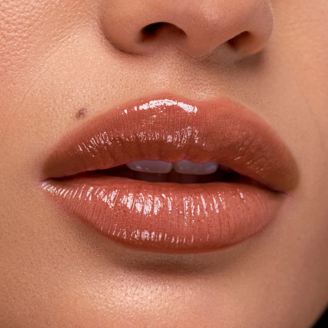 Medium skin tone model wearing Wet Stick in Sunset Simmer