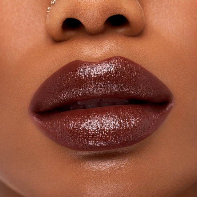 Deep skin tone model wearing Weightless Lip Color in Subconscious