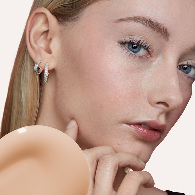 Model wearing Revealer Skin-Improving Foundation SPF 25 in Very Light Cool 120