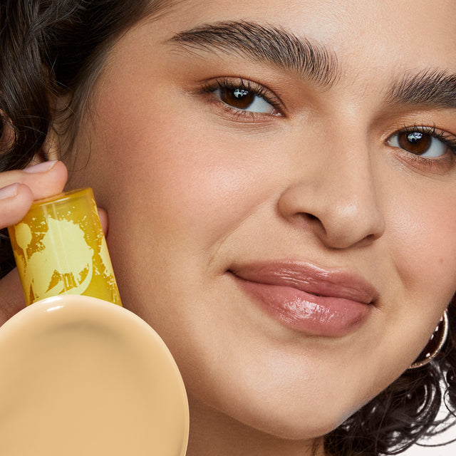 Model wearing Revealer Skin-Improving Foundation SPF 25 in Light+ Neutral Olive 160