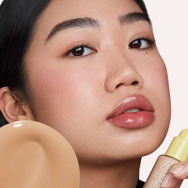 Model wearing Revealer Skin-Improving Foundation SPF 25 in Light Medium Neutral 200