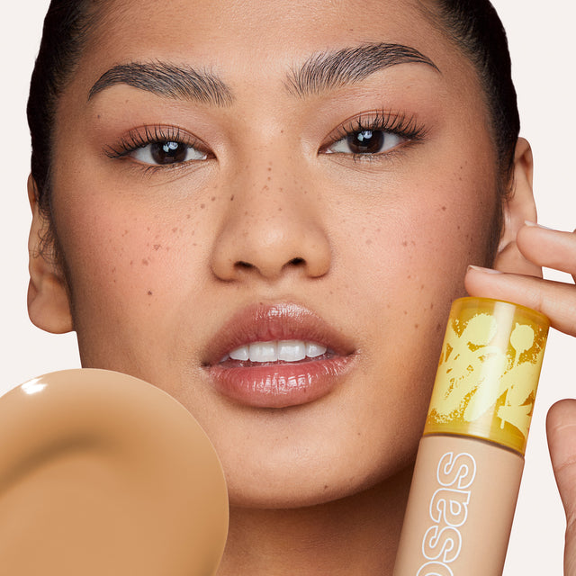 Model wearing Revealer Skin-Improving Foundation SPF 25 in Medium Neutral 220