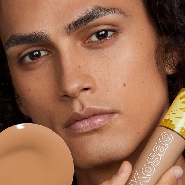Model wearing Revealer Skin-Improving Foundation SPF 25 in Medium Tan Neutral 280