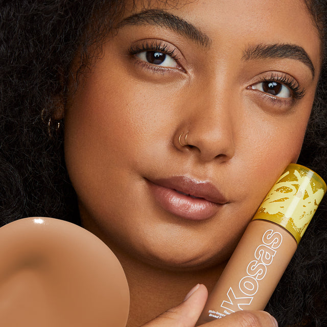 Model wearing Revealer Skin-Improving Foundation SPF 25 in Medium Deep Warm 300