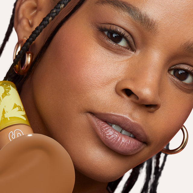 Model wearing Revealer Skin-Improving Foundation SPF 25 in Medium Deep Warm 350