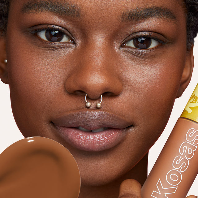 Model wearing Revealer Skin-Improving Foundation SPF 25 in Deep Neutral 380