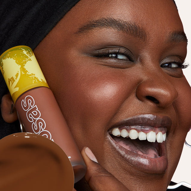 Model wearing Revealer Skin-Improving Foundation SPF 25 in Deep Neutral Warm 410