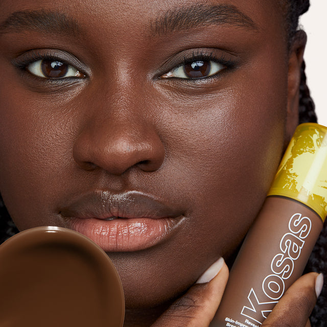 Model wearing Revealer Skin-Improving Foundation SPF 25 in Rich Deep Neutral 440