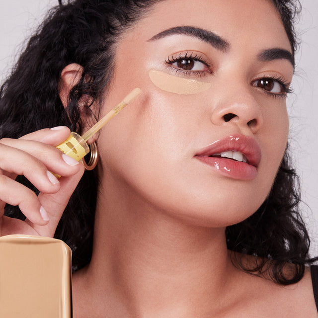 Model wearing Mini Revealer Concealer in Tone 06 O