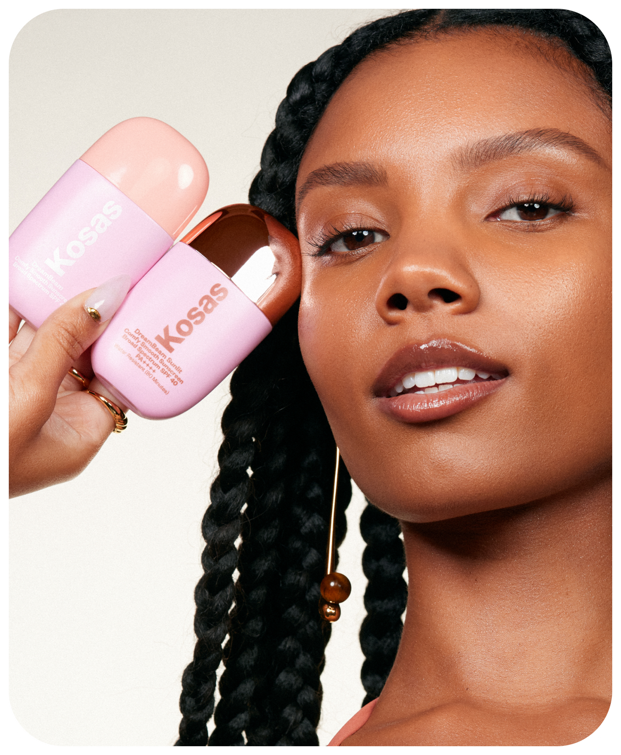 Model holding the two variants of Kosas Dreambeam: Kosas dreambeam: Original and Sunlit