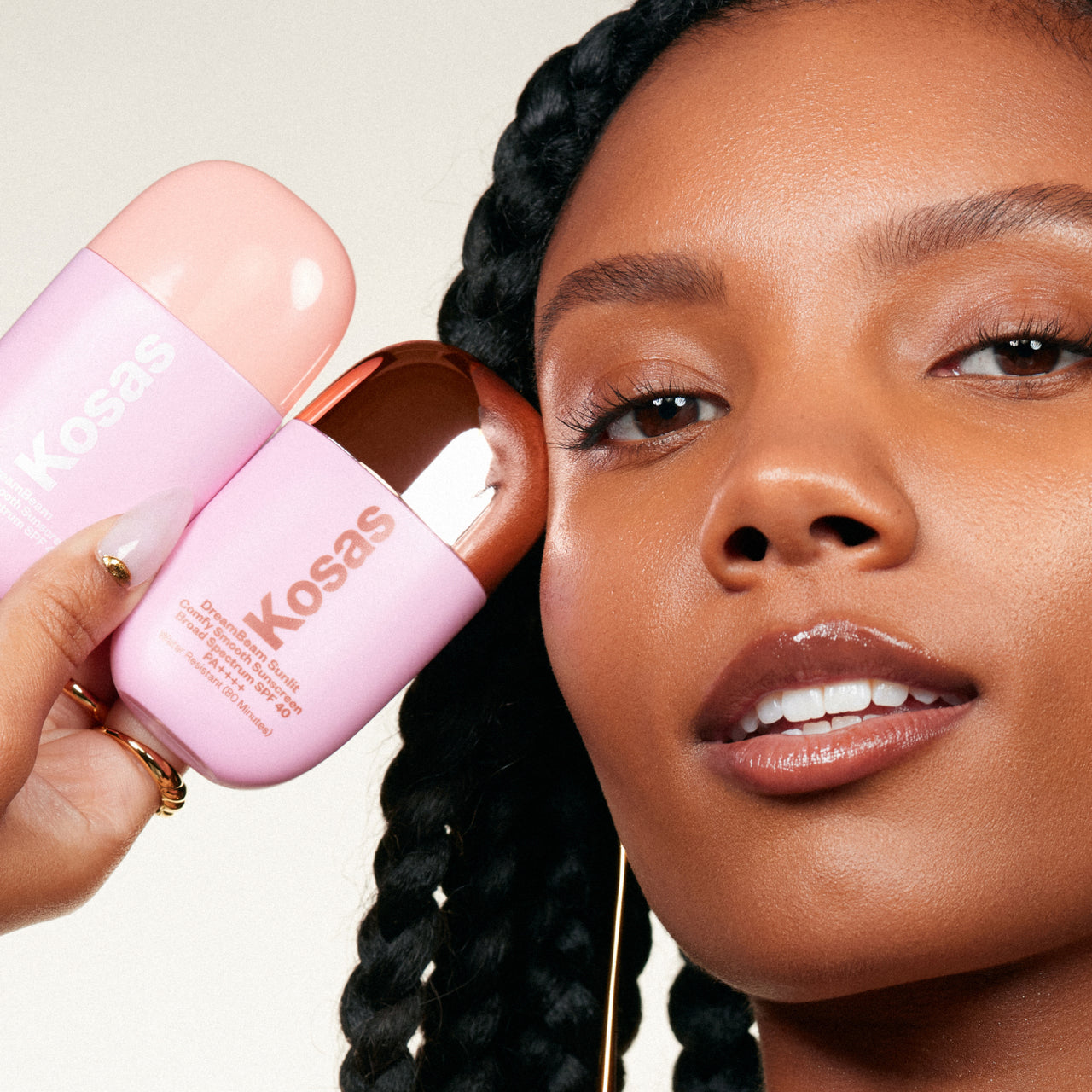 Model holding the two variants of Kosas Dreambeam: Kosas dreambeam: Original and Sunlit