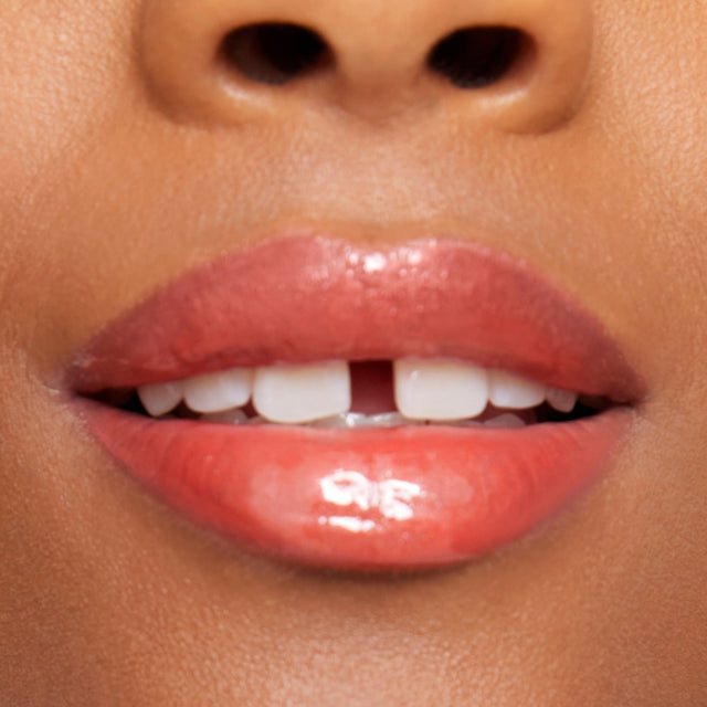 Deep skin tone model wearing Wet Lip Oil Gloss in Dip
