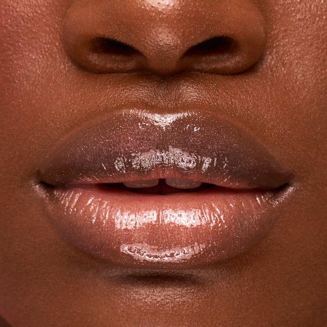 Deep skin tone model wearing Wet Lip Oil Gloss in Exposed