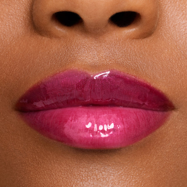 Deep skin tone model wearing Wet Lip Oil Gloss in Fruitjuice