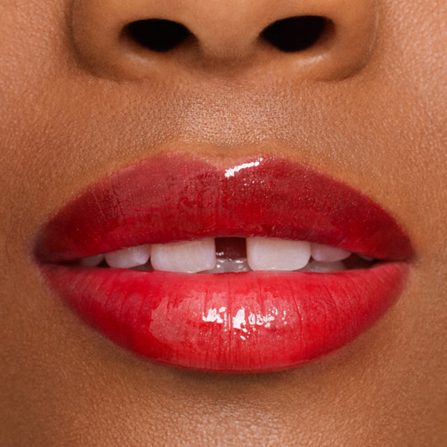 Deep skin tone model wearing Wet Lip Oil Gloss in Jaws