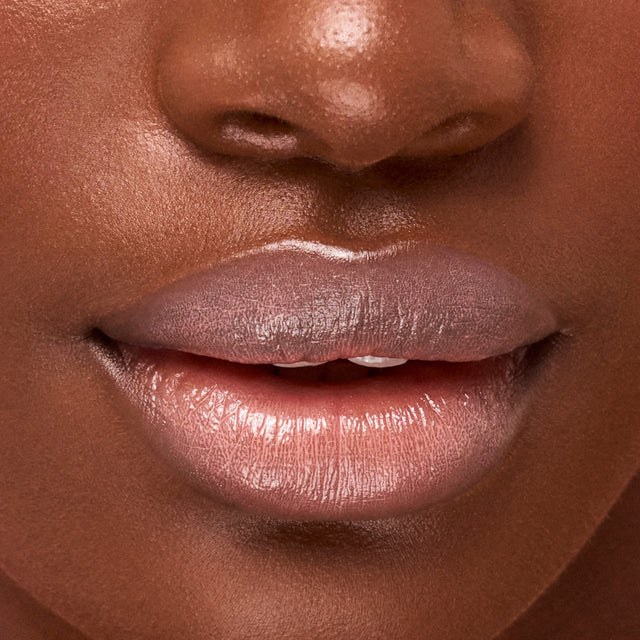 Deep skin tone model wearing Wet Lip Oil Gloss in Revealed