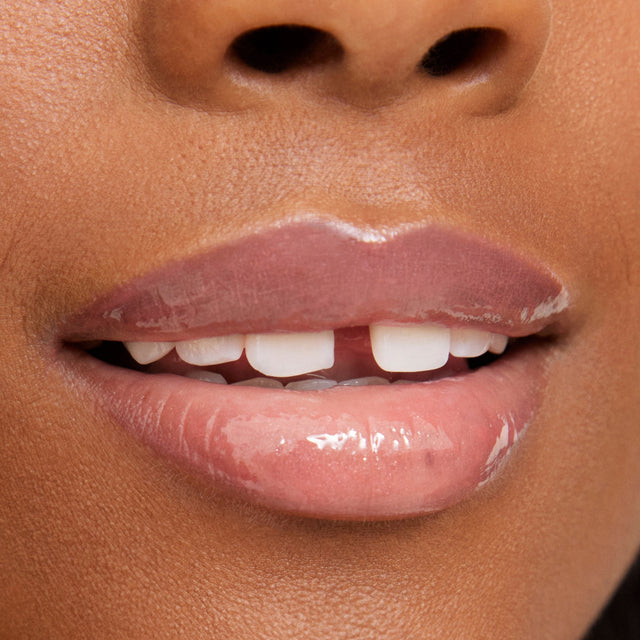 Deep skin tone model wearing Wet Lip Oil Gloss in Unbuttoned