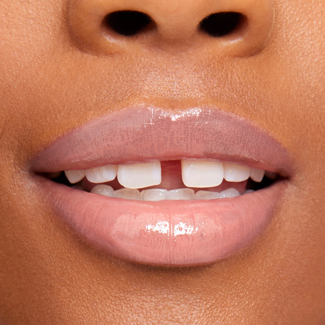 Deep skin tone model wearing Wet Lip Oil Gloss in Unhooked