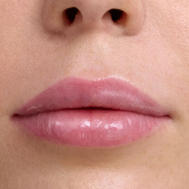 Light skin tone model wearing Wet Lip Oil Gloss in Grapesicle