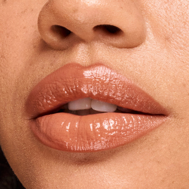 Medium skin tone model wearing Wet Lip Oil Gloss in Bare