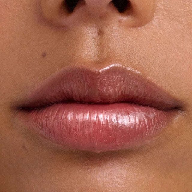 Medium skin tone model wearing Wet Lip Oil Gloss in Cola