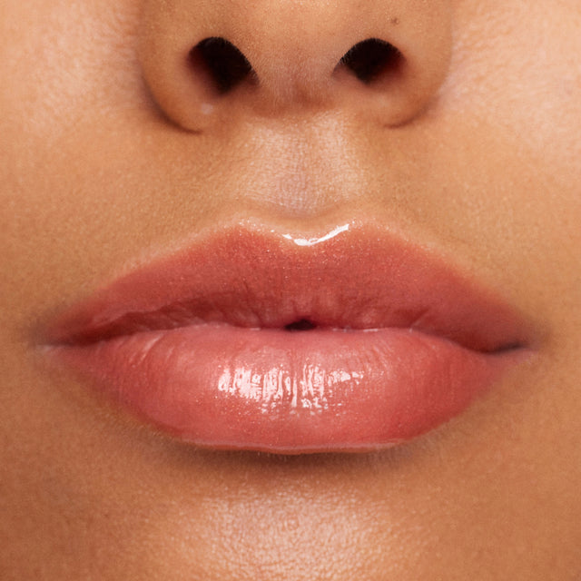 Medium skin tone model wearing Wet Lip Oil Gloss in Dip