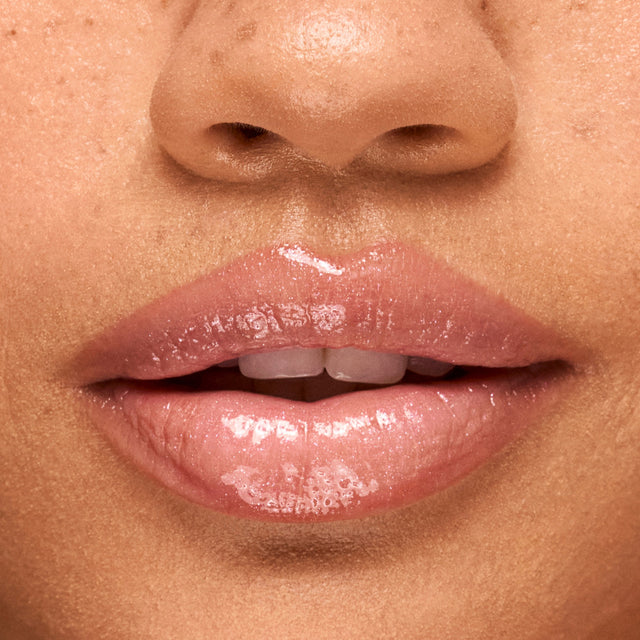 Medium skin tone model wearing Wet Lip Oil Gloss in Exposed