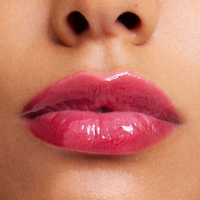 Medium skin tone model wearing Wet Lip Oil Gloss in Fruitjuice
