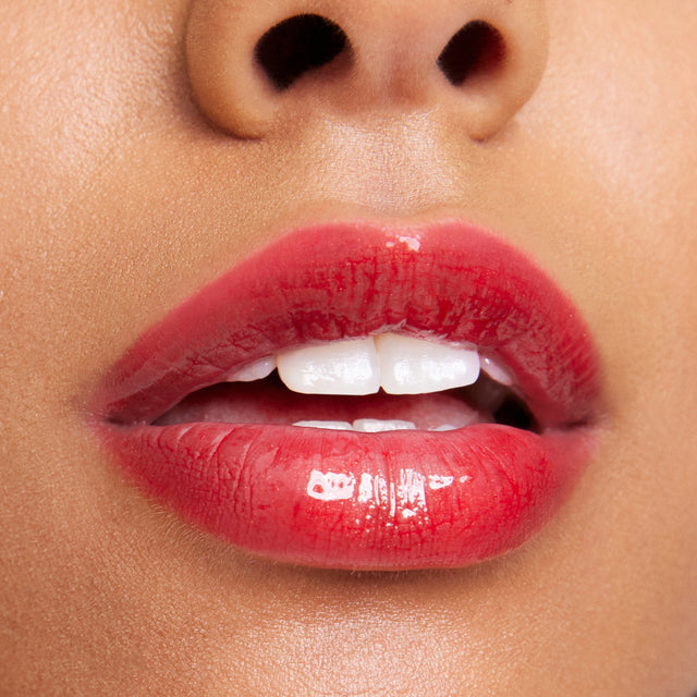 Medium skin tone model wearing Wet Lip Oil Gloss in Jaws