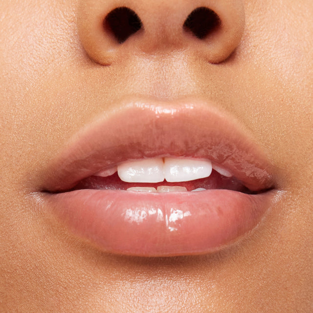 Medium skin tone model wearing Wet Lip Oil Gloss in Jellyfish