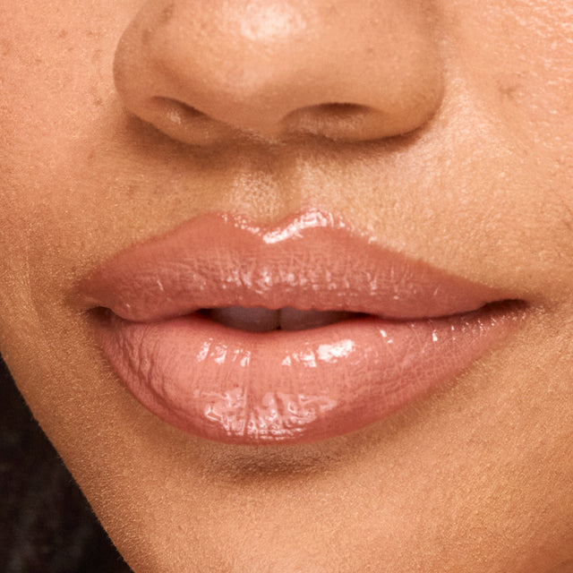Medium skin tone model wearing Wet Lip Oil Gloss in Revealed