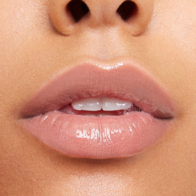 Medium skin tone model wearing Wet Lip Oil Gloss in Unhooked