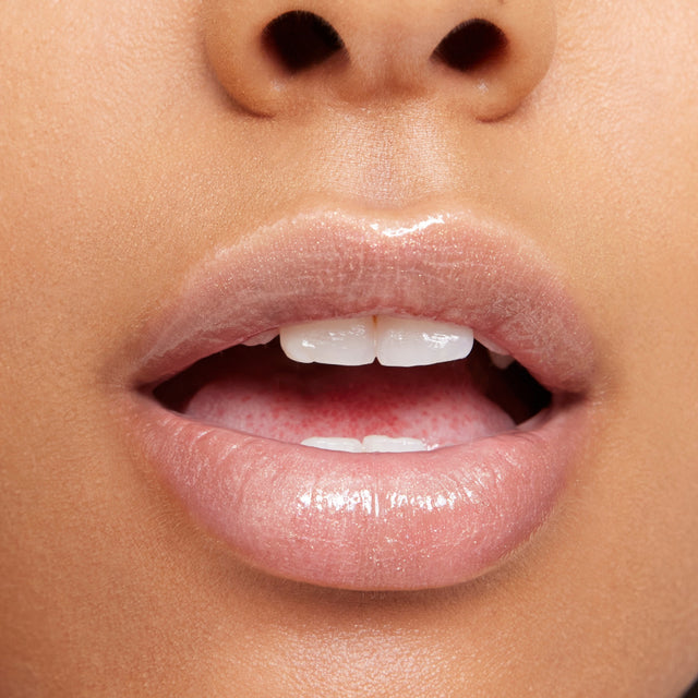 Medium skin tone model wearing Wet Lip Oil Gloss in Unzipped