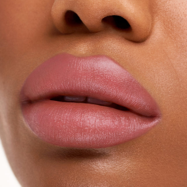 Deep skin tone model wearing Weightless Lip Color in Rosewater