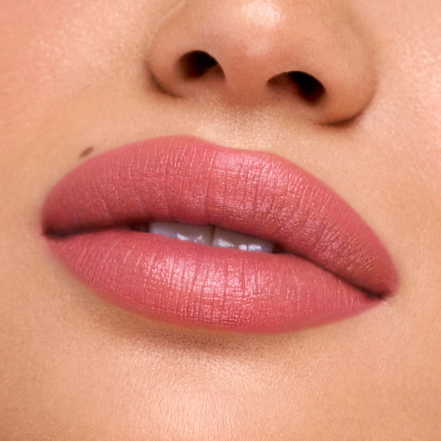 Medium skin tone model wearing Weightless Lip Color in Rosewater